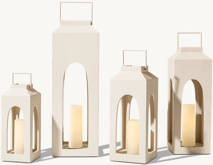 Set of modern white lanterns with candles for outdoor lighting.