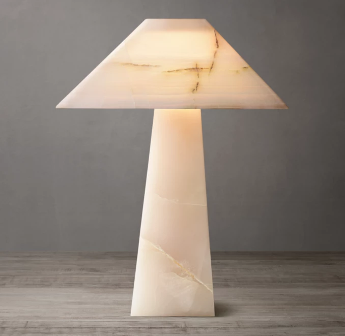 Elegant onyx stone table lamp with obelisk design and warm lighting.