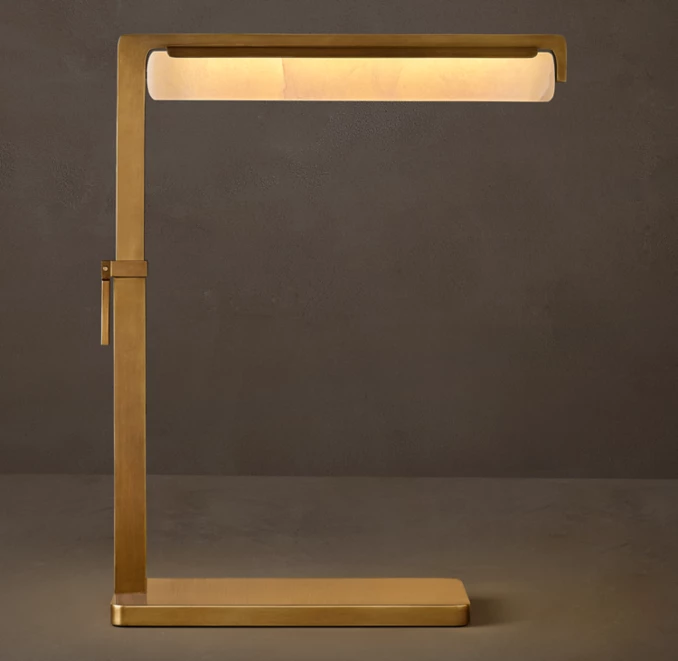 Brass task lamp with modern design and adjustable arm for focused lighting.