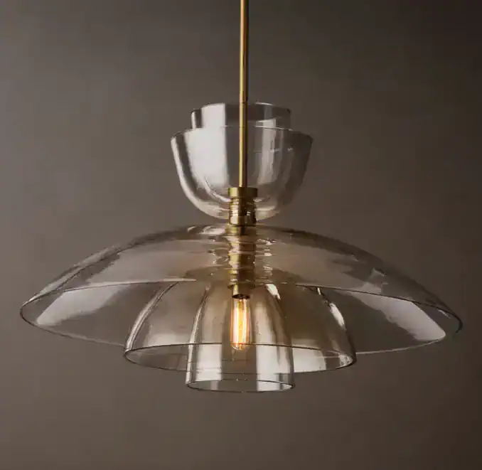 Elegant glass cloche pendant light with gold accents for modern interiors.