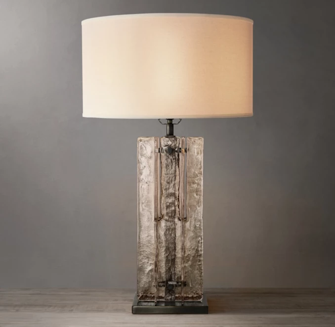 Elegant smoke glass table lamp with a modern design and beige lampshade.