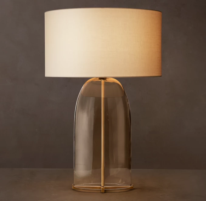 Elegant glass table lamp with steel base and fabric shade for modern decor.