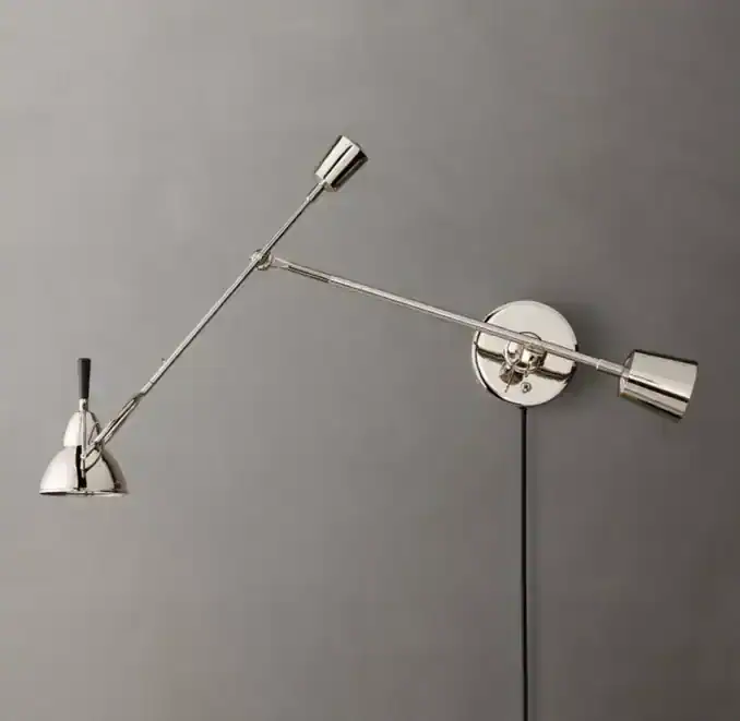 Modern brass wall sconce with adjustable arms and minimalist design.