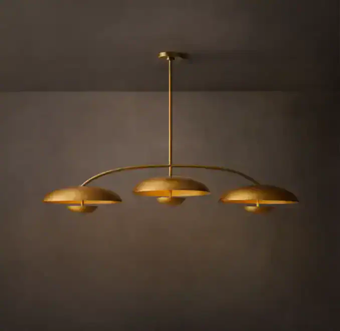 Elegant gold linear chandelier with three curved shades for modern interiors.