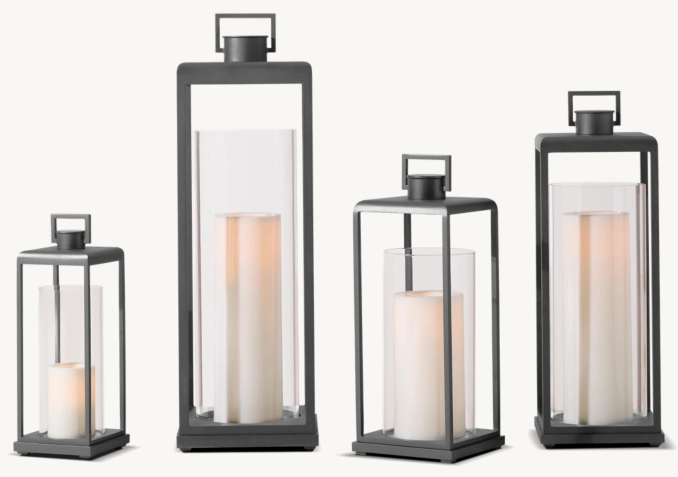 Modern black metal lanterns with white candles for decor.