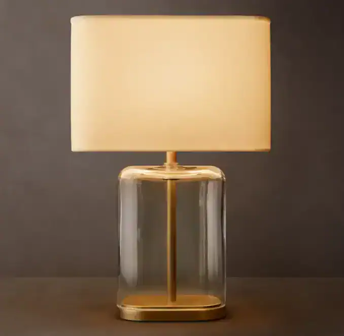 Modern glass table lamp with linen shade for elegant lighting.