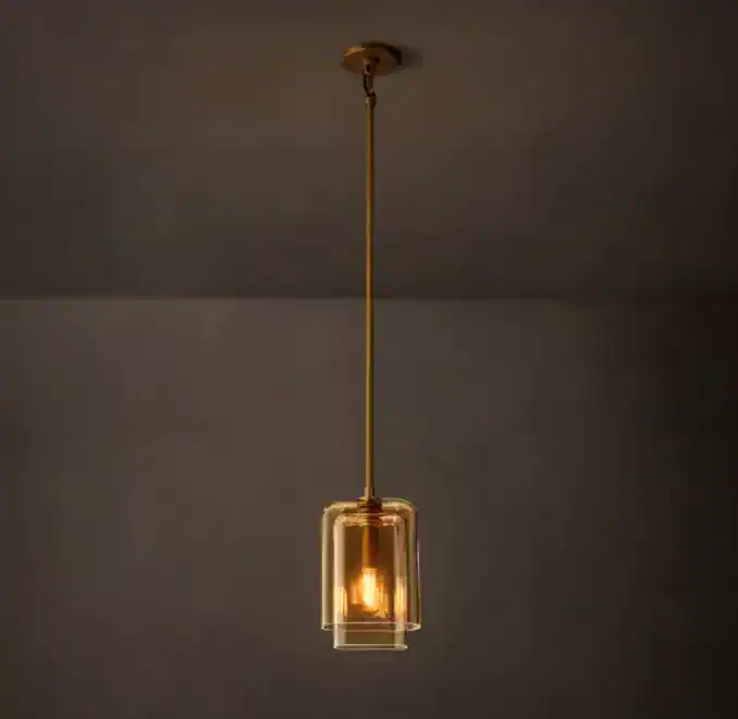 Modern amber glass pendant light hanging from ceiling with gold fixture.