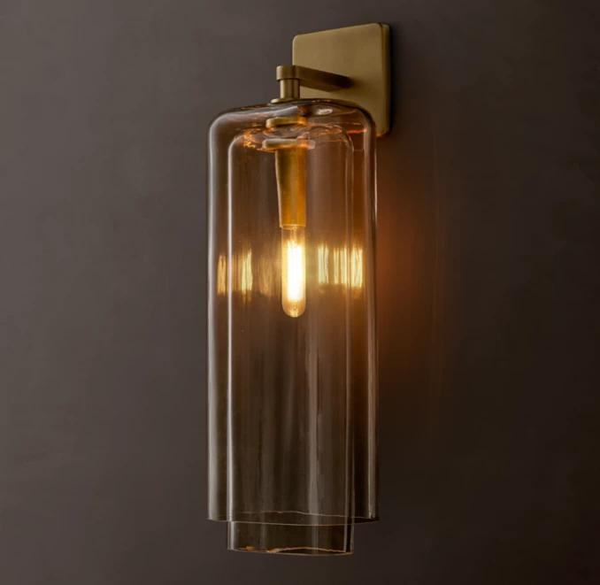 Modern amber glass wall sconce with warm lighting for interior decor.