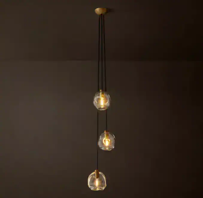 Modern glass globe pendant light with three hanging bulbs for stylish illumination.