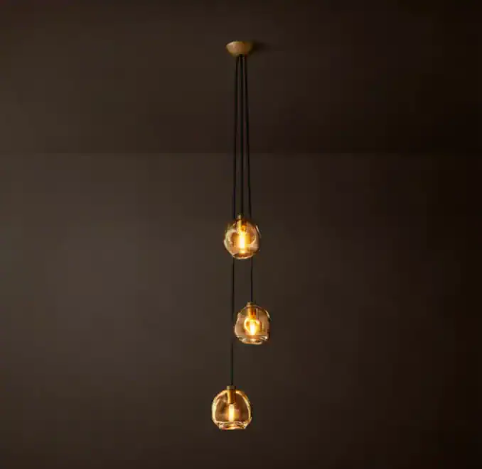 Modern glass globe pendant light with three hanging bulbs for stylish lighting.