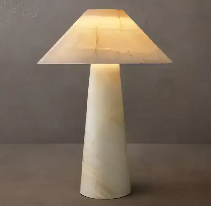 Modern stone table lamp with a conical base and fabric shade for ambient lighting.