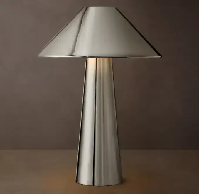 Contemporary metal table lamp with a sleek, conical base and a wide, metallic shade.