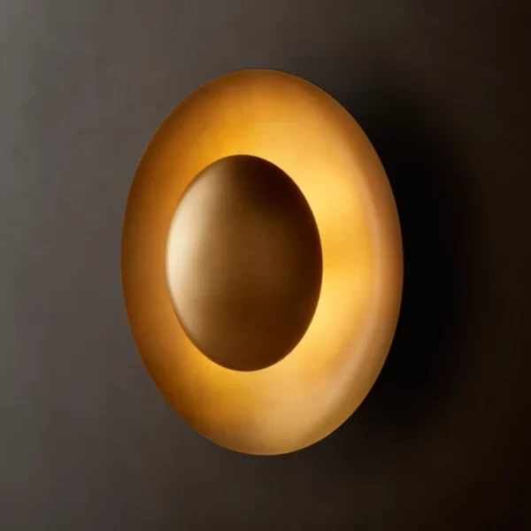 Modern steel wall sconce with circular design and warm lighting.