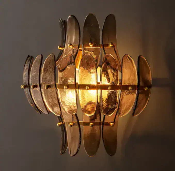Modern wall sconce with metallic petal design and warm lighting.
