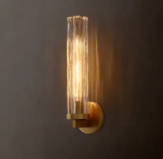Elegant glass wall sconce with warm lighting for modern interior decor.