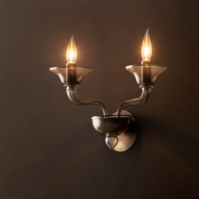 Modern double wall sconce with glass shades and candle-style bulbs.