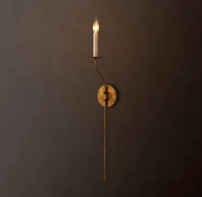 Elegant wall sconce with candle-style light and rustic finish.
