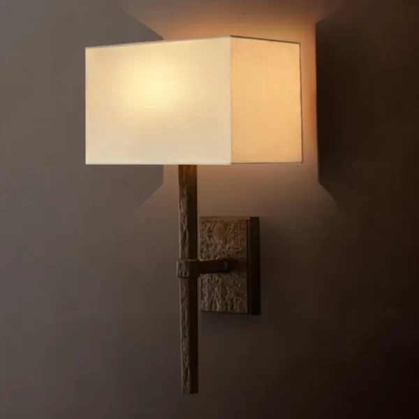 Gorvey lighting sconce with linen shade and cast aluminum arm.