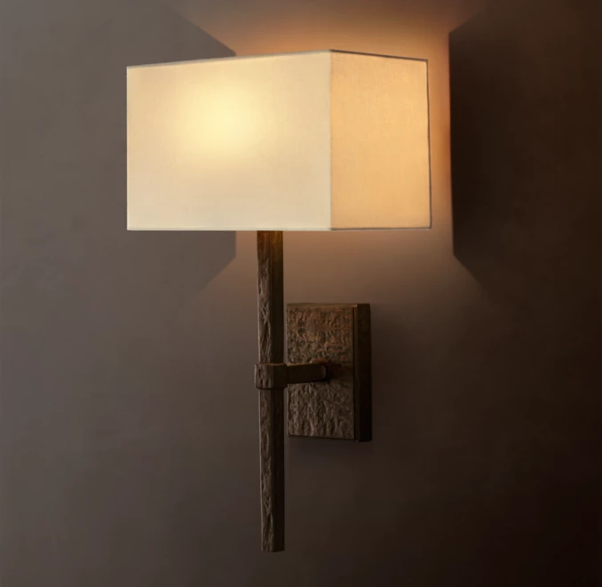 Gorvey lighting sconce with linen shade and cast aluminum arm.