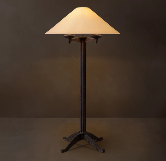 Rustic iron floor lamp with a beige lampshade for elegant lighting.