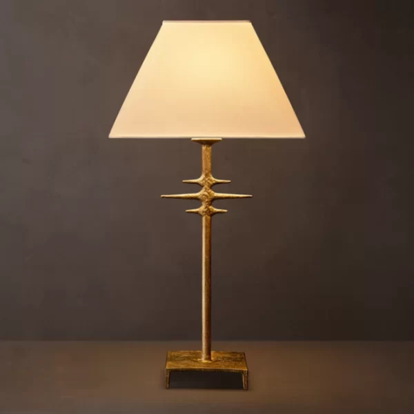 Modern metal table lamp with a beige lampshade and gold finish base.