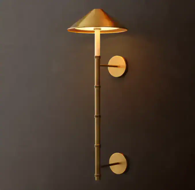 Modern wall sconce with bamboo-inspired design and warm lighting.