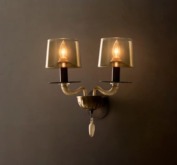 Elegant double wall sconce with glass shades and vintage bulbs for ambient lighting.
