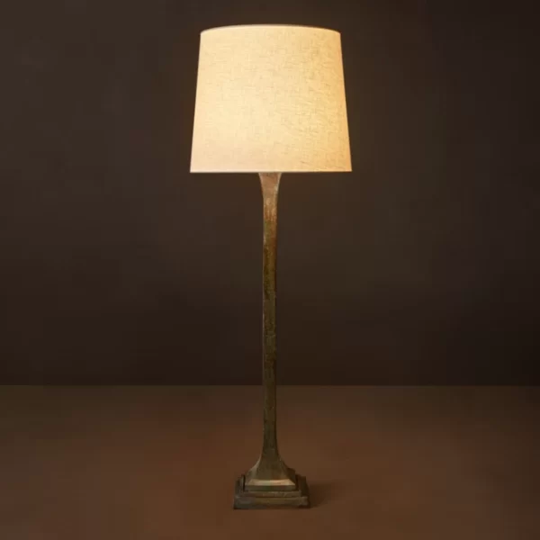 Elegant brass craft lamp with beige lampshade on dark background.