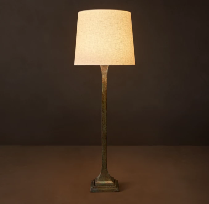 Elegant brass craft lamp with beige lampshade on dark background.