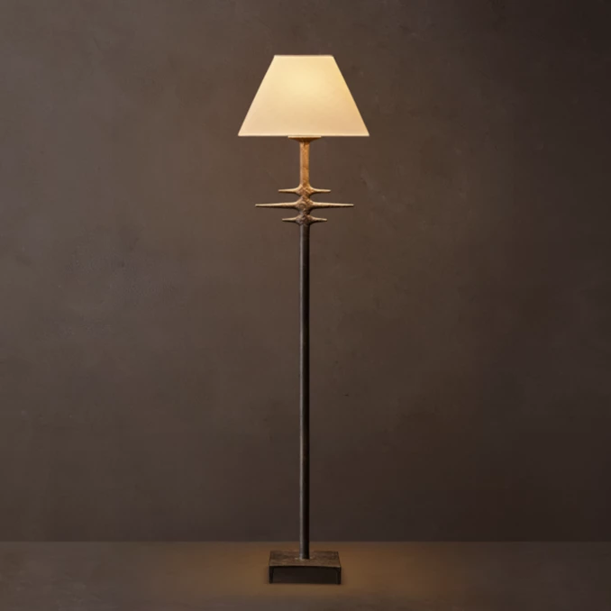 Modern metal floor lamp with linen shade and unique design accents.