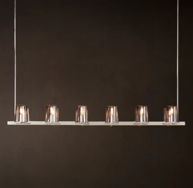 Modern linear brass light fixture with six glass shades for elegant lighting.