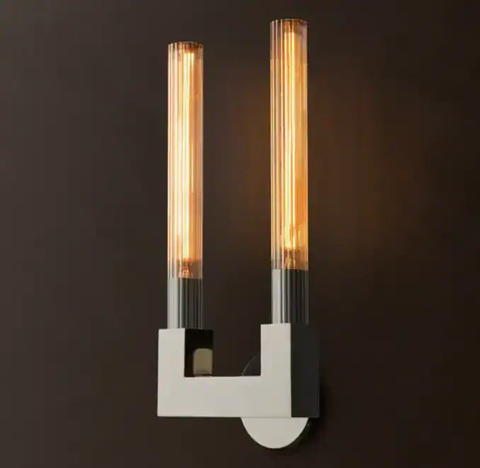 Modern double brass glass sconce with warm lighting for interior decor.