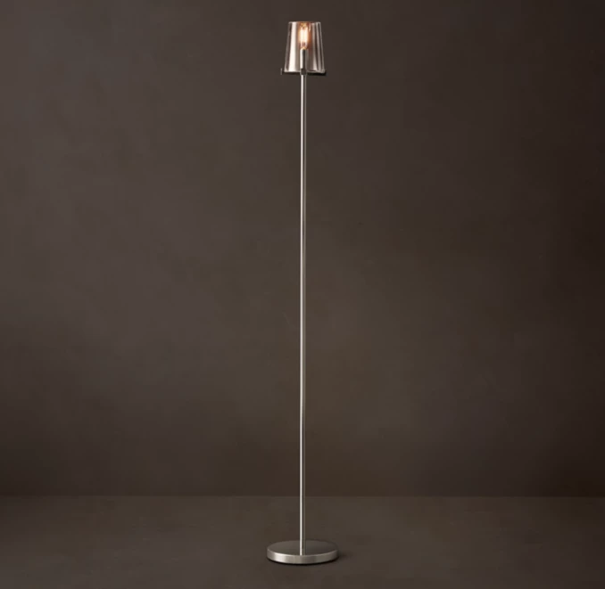 Modern floor lamp with a sleek metal stand and a glass shade for stylish lighting.