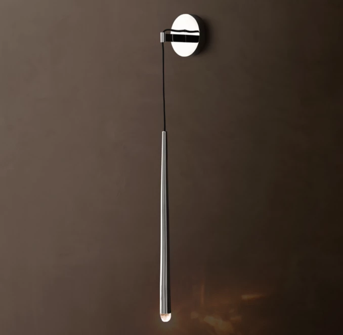 Modern brass wall sconce with pull chain for ambient lighting.