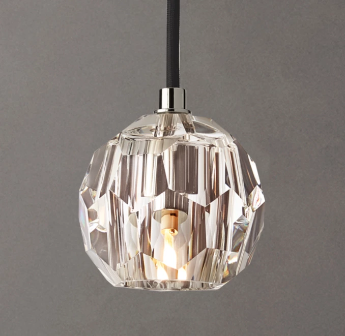 Elegant crystal pendant light with brass accents for modern interiors.